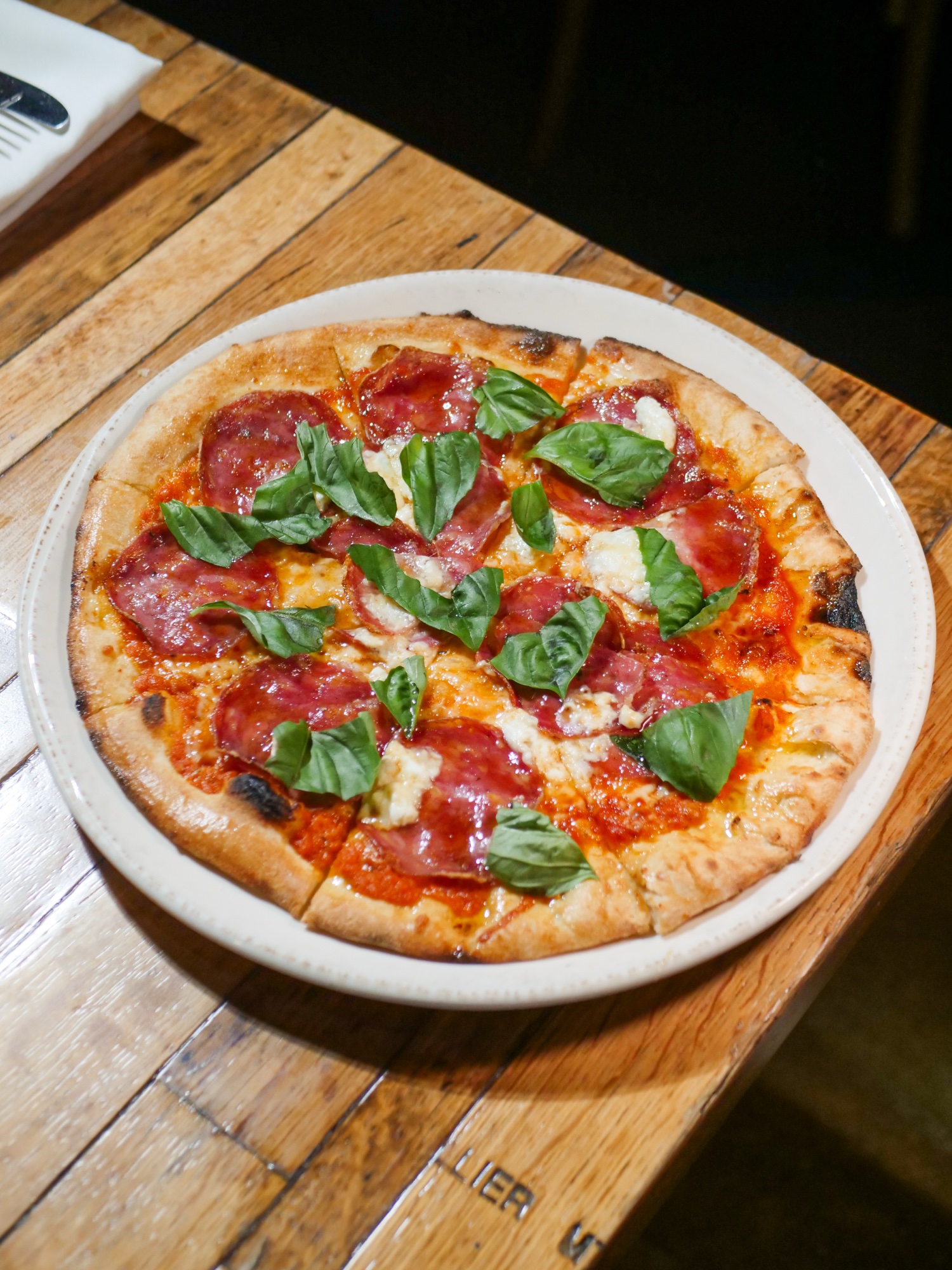 A wood-fired Bee Sting pizza with soppressata, burrata and chili honey at Tin Roof Bistro