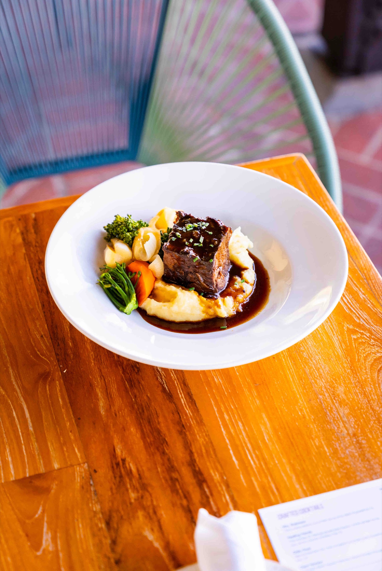 Wine-braised bone-in beef short ribs over white truffle polenta at Tin Roof Bistro