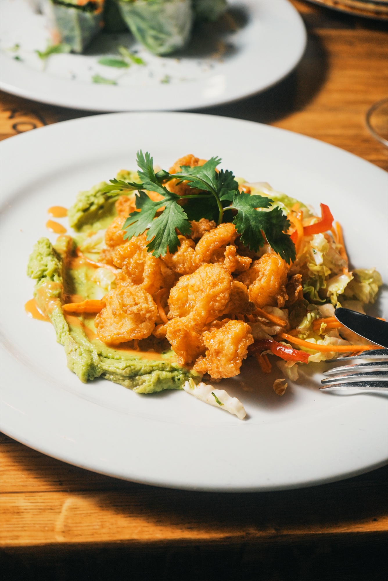 Crispy firecracker shrimp over avocado purée with Napa slaw at Tin Roof Bistro