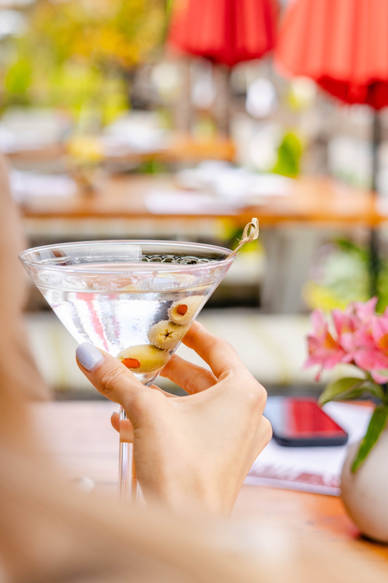 A classic olive martini held on the sunny patio at Tin Roof Bistro