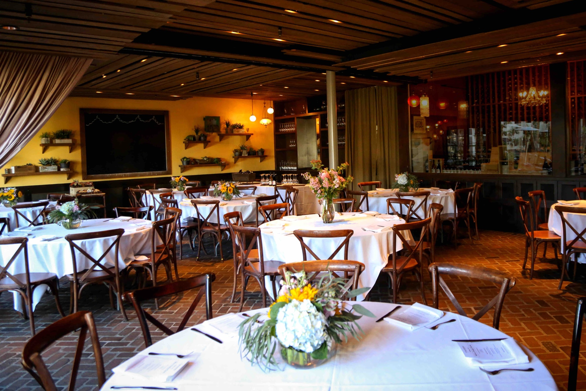 The Wine Cellar private dining room set with linens and florals for an event at Tin Roof Bistro